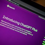 A section of a laptop screen shows a browser pointed to OpenAI's introduction of ChatGPT. The website is purple with light green text.